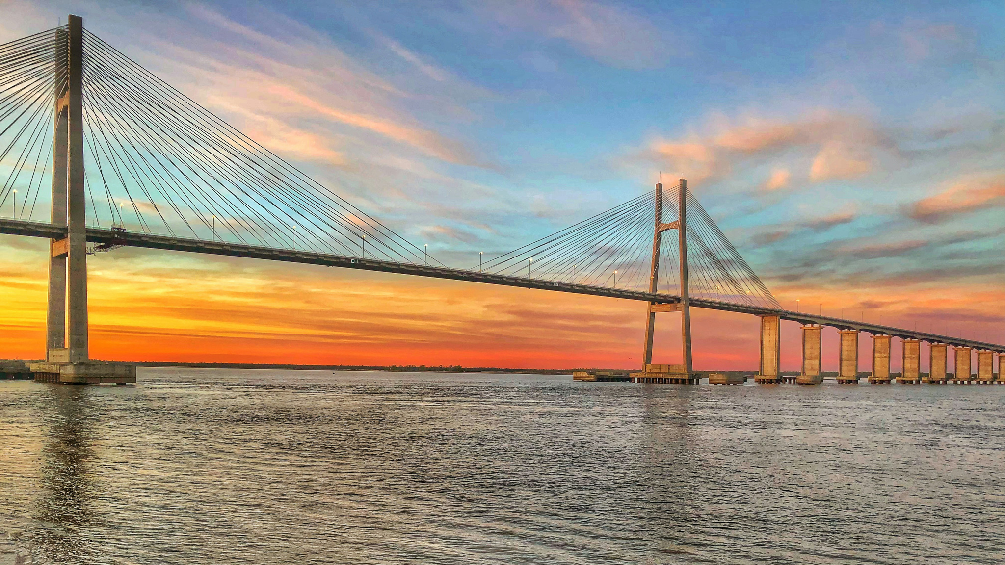 A picturesque bridge over calm waters at sunset, creating a serene and captivating scene.