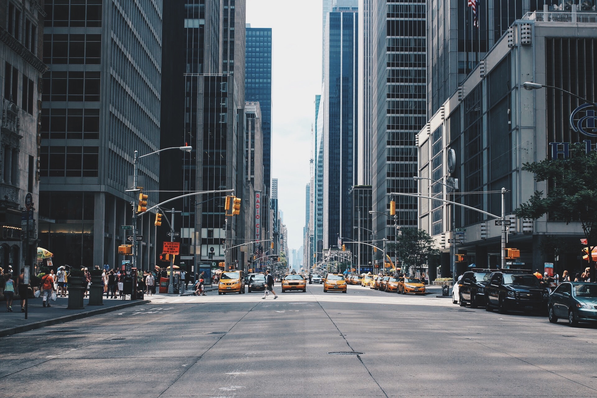 New York city. A street and taxis coming in the distance. All the skyscrapers at the side.